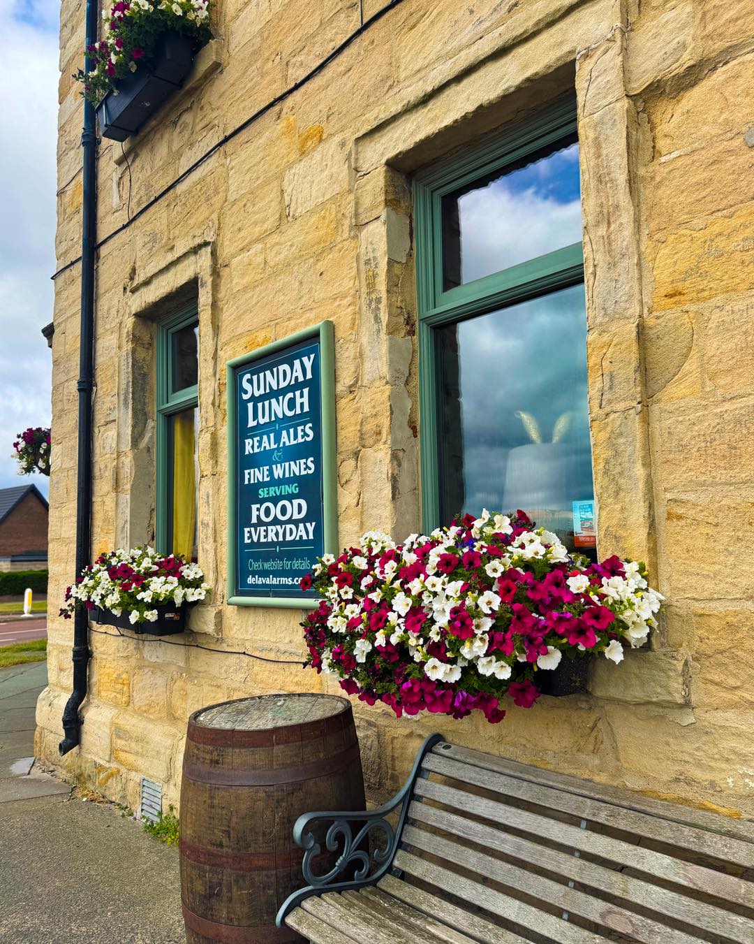 Flower filled window boxes on the stone exterior of the Delaval Arms